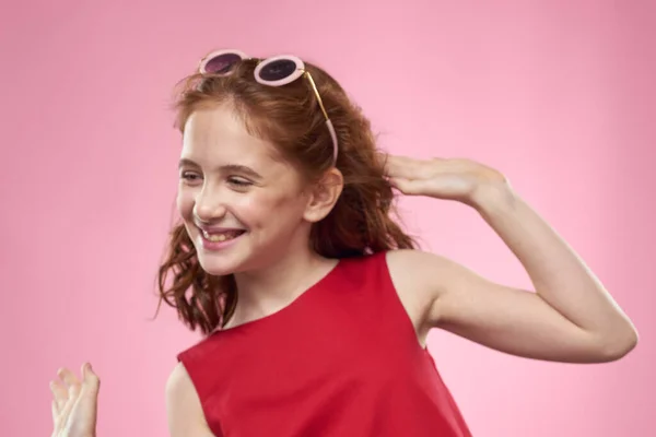 Mädchen mit lockigem Haar Sonnenbrille Kindheit Freude rosa Hintergrund — Stockfoto
