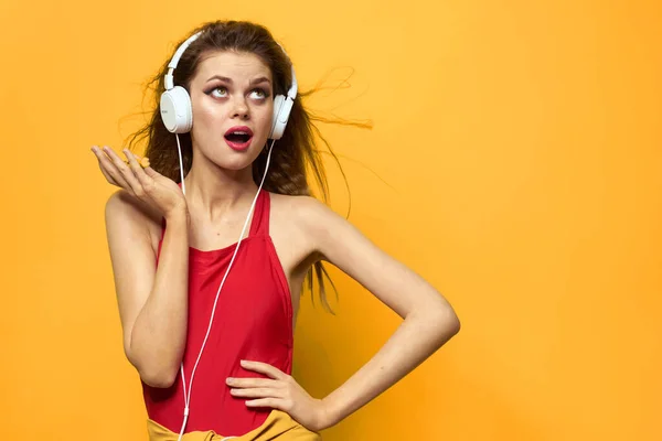Mulher emocional em fones de ouvido brancos escuta música divertida estilo de vida fundo amarelo — Fotografia de Stock