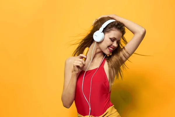 Эмоциональная женщина в белых наушниках слушает музыку веселого образа жизни желтый фон — стоковое фото