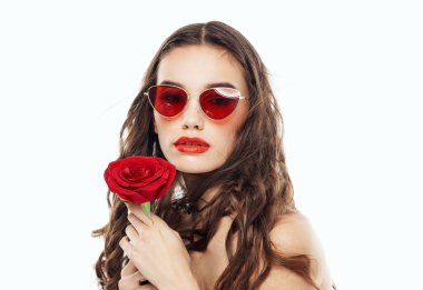 Kırpılmış gözlüklü seksi esmer ellerinde kırmızı çiçekle