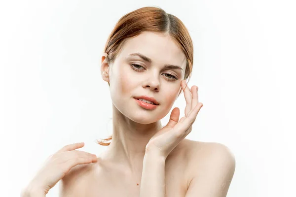 Mujer cogida de la mano cerca de la cara posando modelo luz fondo — Foto de Stock