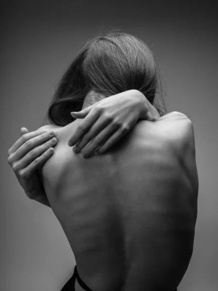 Zwart-wit foto van een lang haar model aanraken van zichzelf met de handen — Stockfoto