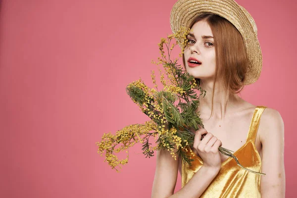 Vacker kvinna i en hatt gyllene klänning buketter av blommor semester — Stockfoto