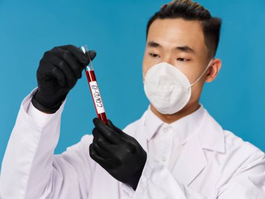 Siyah koruyucu eldivenli Asyalı erkek kan biyokimyası CV19 incelemesi