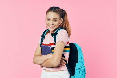Sırt çantası eğitimi almış liseli kız pembe arka plan eğitimi alıyor.