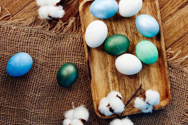 Huevos coloridos Pascua vacaciones decoración tablero de madera vista superior —  Fotos de Stock