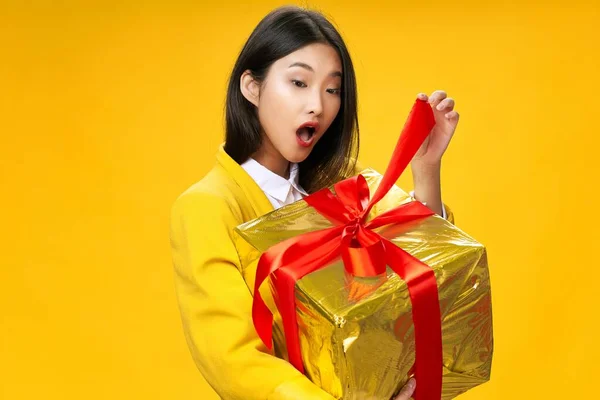 Mujer con un regalo en sus manos sorpresa amarillo fondo vacaciones —  Fotos de Stock