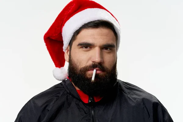 Noel Baba şapkalı sakallı adam ağzında sigarayla kötü duygular besliyor. — Stok fotoğraf