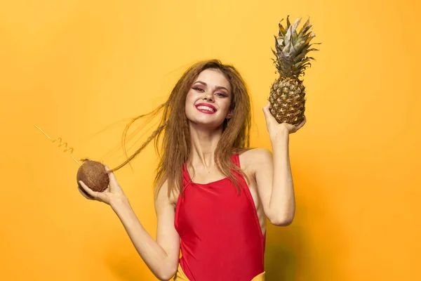 Mulher com abacaxi e coco coquetel frutas exóticas verão estilo de vida fundo amarelo — Fotografia de Stock