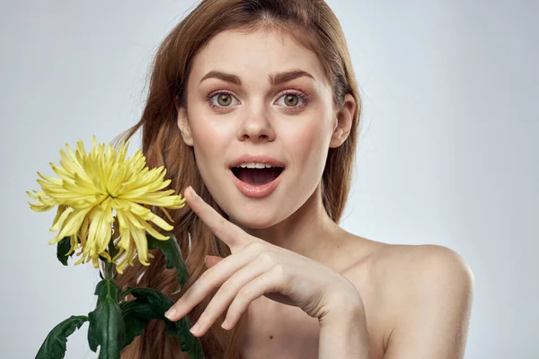 Portrait d'une belle femme avec une fleur jaune sur un fond clair recadré d'espace de copie Modèle — Photo