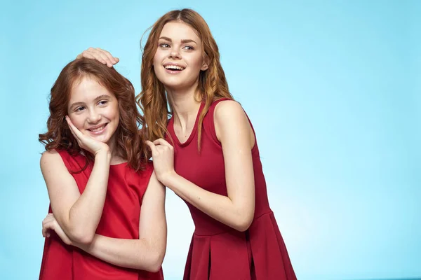 Семья мама и дочь обнимают красный платья коммуникации эмоции синий фон — стоковое фото