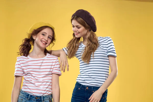 funny mom and daughter wearing hats fashion fun joy family yellow background