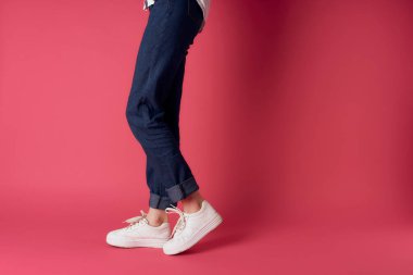 Kadınların ayakları beyaz spor ayakkabılar moda sokak tarzı pembe arka plan