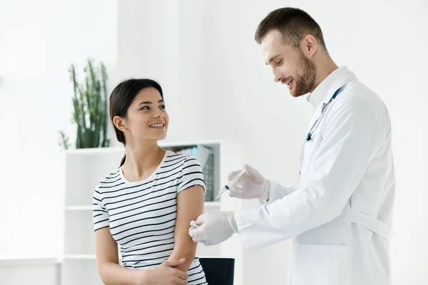 Erkek doktor, bir kadına aşı yapıyor. — Stok fotoğraf