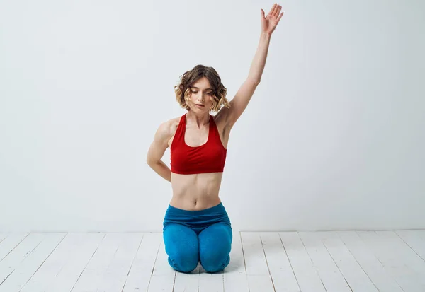 Vrouw in sportkleding op een lichte achtergrond gebaren met haar handen yoga asana — Stockfoto