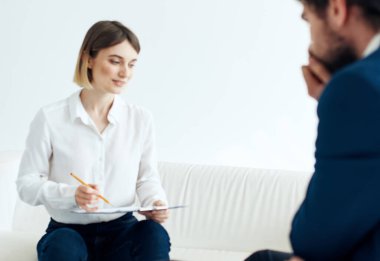 Belgeleri olan bir kadın ve koltukta oturan takım elbiseli bir adam boş oda kiralıyor.