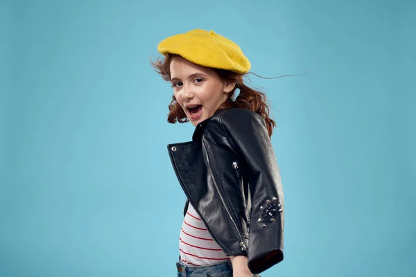 Vrolijk schattig meisje in gele hoed kleding studio blauwe achtergrond — Stockfoto