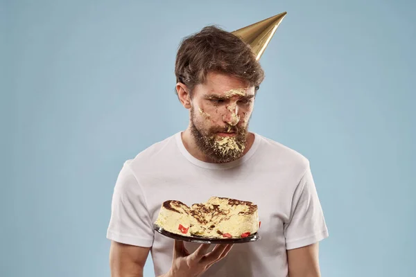 Bearded man in a holiday cap Birthday cake emotions