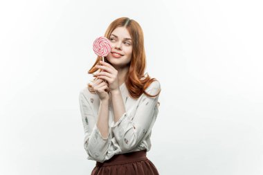 Ellerinde lolipopla güzel bir kadın. Tatlıdan zevk alıyor.