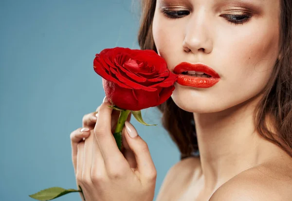 Romantische mensen met een rode roos in hun handen op een blauwe achtergrond bijgesneden uitzicht — Stockfoto