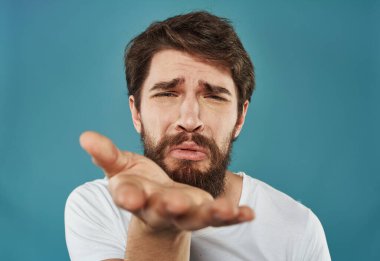 Mavi bir arka plan üzerinde elleri ile hareket eden bir adam duyguların yakın plan portresi