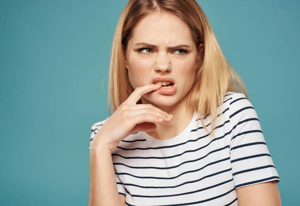 Mulher descontente em T-shirt listrada no fundo cortado azul com espaço de cópia — Fotografia de Stock