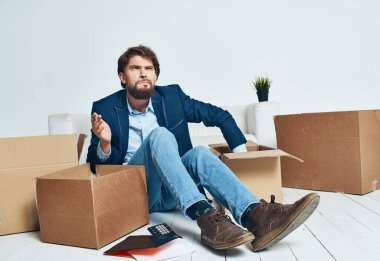 İşadamı karton kutuları toplayıp yeni bir yere taşınıyor.