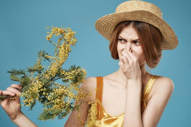 Kadın burnunu hoş olmayan bir çiçek buketiyle kapatıyor.