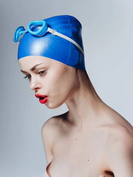 Retrato de uma mulher nadadora em um boné azul e óculos na cabeça desnudados ombros — Fotografia de Stock