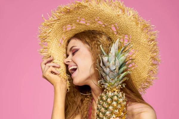 Glada kvinna i hatt ananas händer Exotisk sommar resa rosa bakgrund — Stockfoto