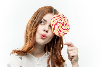 Sevimli kızıl saçlı kadın lolipop lolipop yuvarlak cazibe kırpılmış manzara