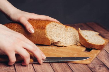 Kesme tahtasında somun dilimlemek ahşap masa yemeği un ürünü.