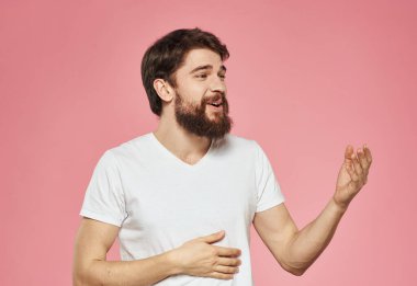 Duygusal bir adam pembe arka planda el kol hareketi yapıyor.