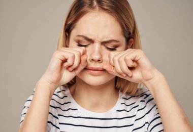 Üzgün kadın bej arka planda ağlıyor. Duygular yok oluyor.