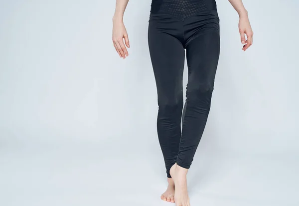 Deportiva mujer sobre un fondo claro en leggings negro descalzo — Foto de Stock
