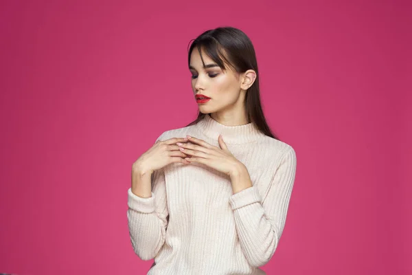 Morena con el pelo largo labios rojos cosméticos suéter blanco rosa fondo recortado ver —  Fotos de Stock