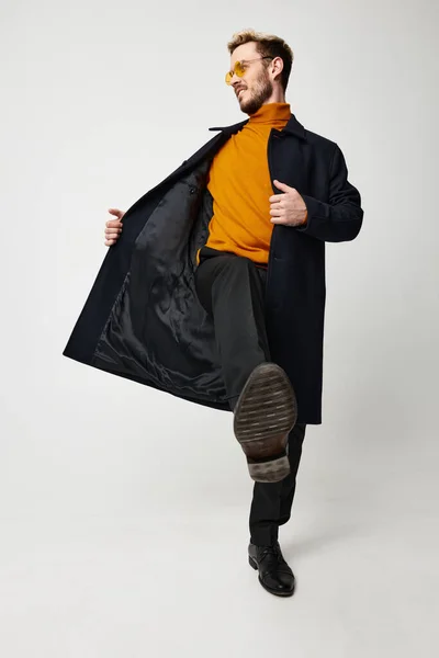 Aranyos srác egy narancssárga pulóver kigombolt kabát nadrág modell fény háttér — Stock Fotó