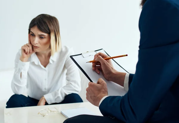 Een man in een klassiek pak met documenten in zijn handen en een emotionele vrouw op de bank — Stockfoto