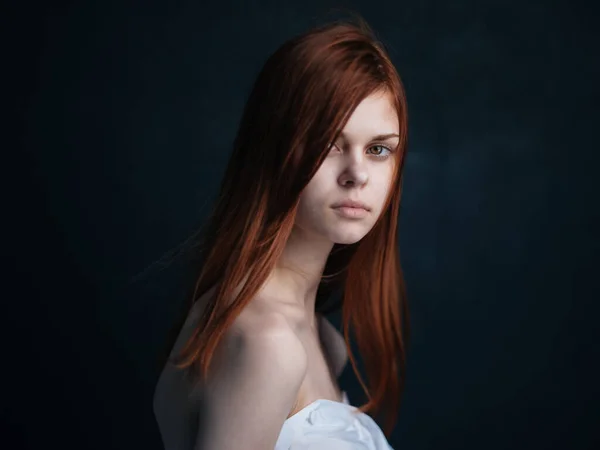 Modello donna sexy con i capelli rossi su uno sfondo nero primo piano vista laterale — Foto Stock