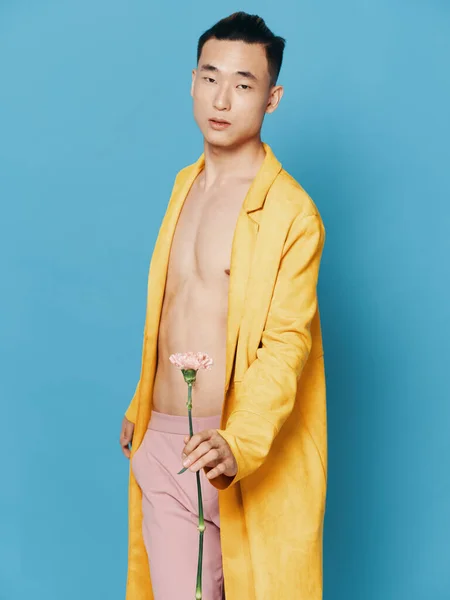 花の黄色のコートの男青の背景ピンクのズボン — ストック写真