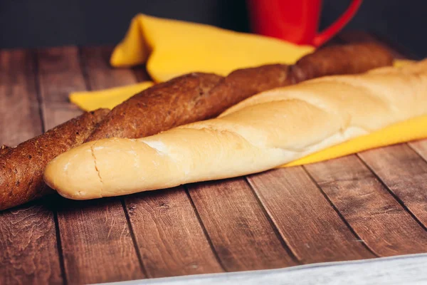 Pão fatiado guardanapo amarelo mesa de madeira assados bens — Fotografia de Stock