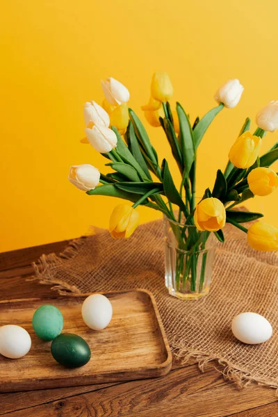 Bouquet de fleurs oeufs de Pâques décoration de vacances fond jaune — Photo