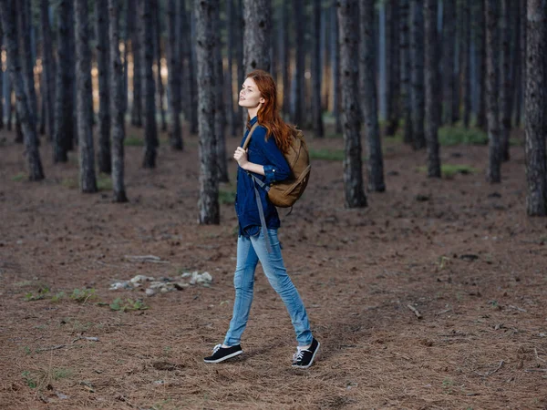 Žena Turistka v plném růstu v borovém lese s batohem na zádech — Stock fotografie
