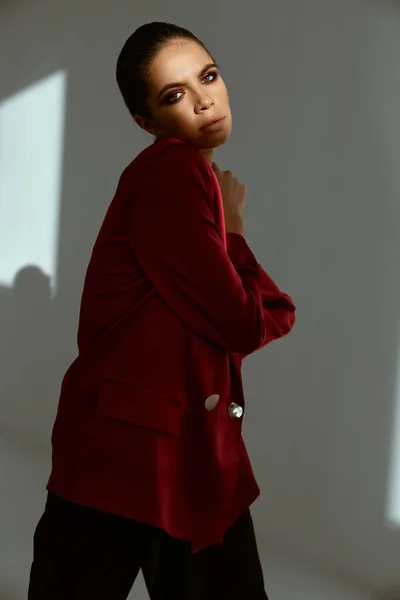 Mujer en chaqueta roja estudio de moda fondo claro — Foto de Stock