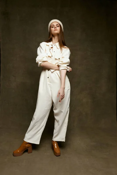 Women on brown background in trendy overalls gesturing with hands and boots — 스톡 사진
