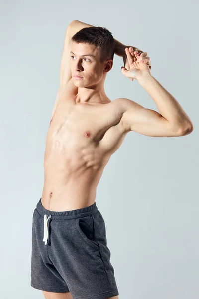 Handsome athlete with an inflated torso holds his hands behind his head bodybuilder Fitness Model — Stock Photo, Image