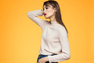 Sevimli esmer makyaj kırmızı dudaklar moda kıyafetler sarı arka plan