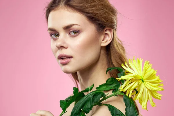 Portret kobiety z żółtymi kwiatami na różowym tle Makijaż na twarzy — Zdjęcie stockowe