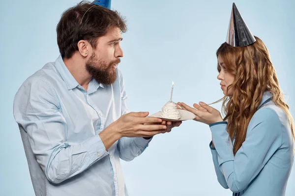 Wesoły mężczyzna i kobieta z ciastem w talerzu korporacyjnej partii niebieskie tło — Zdjęcie stockowe
