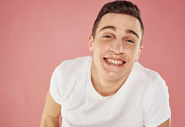 Happy man on pink background gesturing with hands in white t-shirt cropped view — Stock Photo, Image